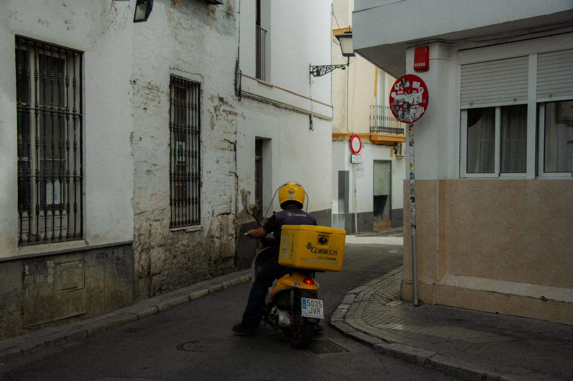 Correos scooter parked in an alley, rear view
