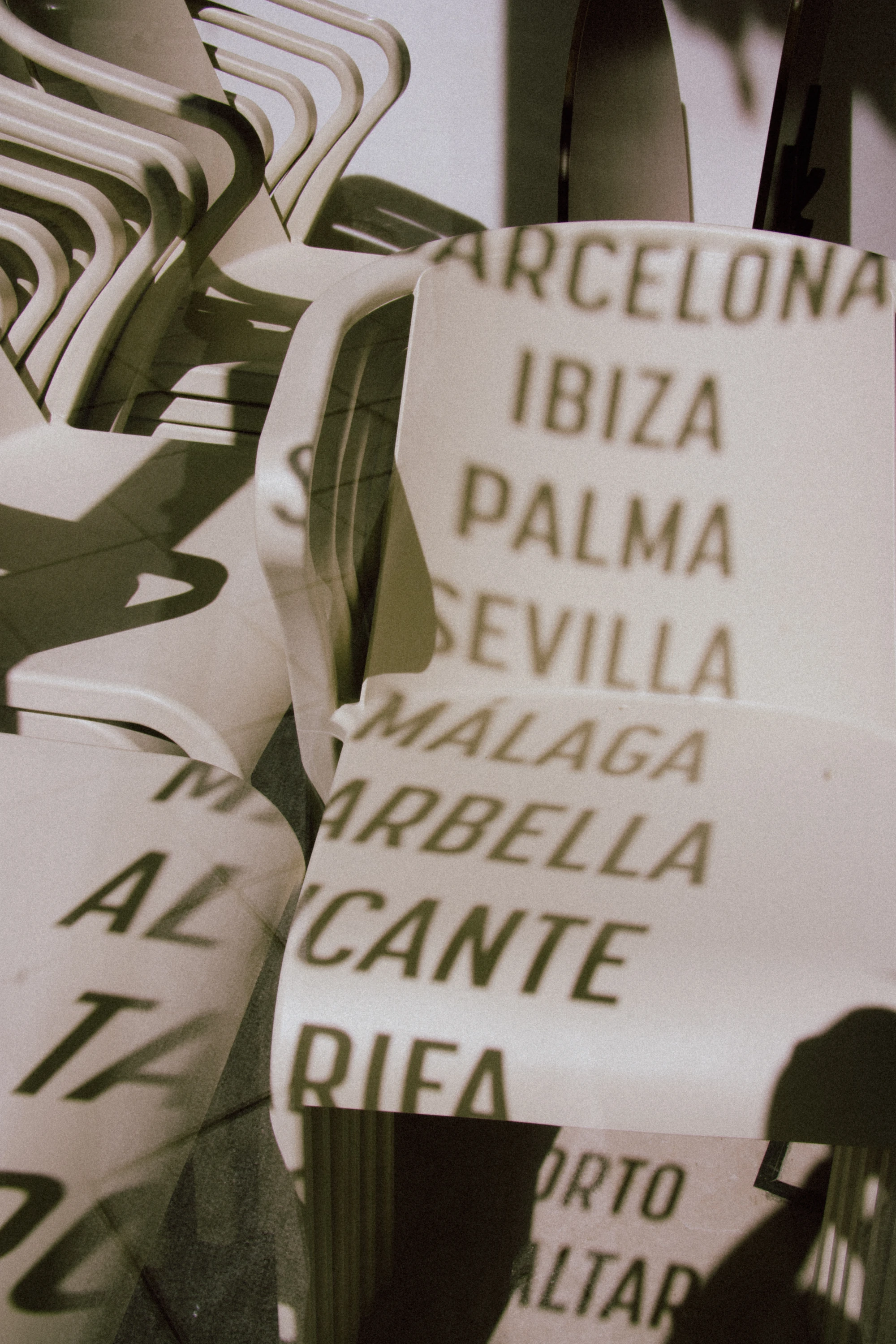 Spanish cities direction sign with stacked chairs below